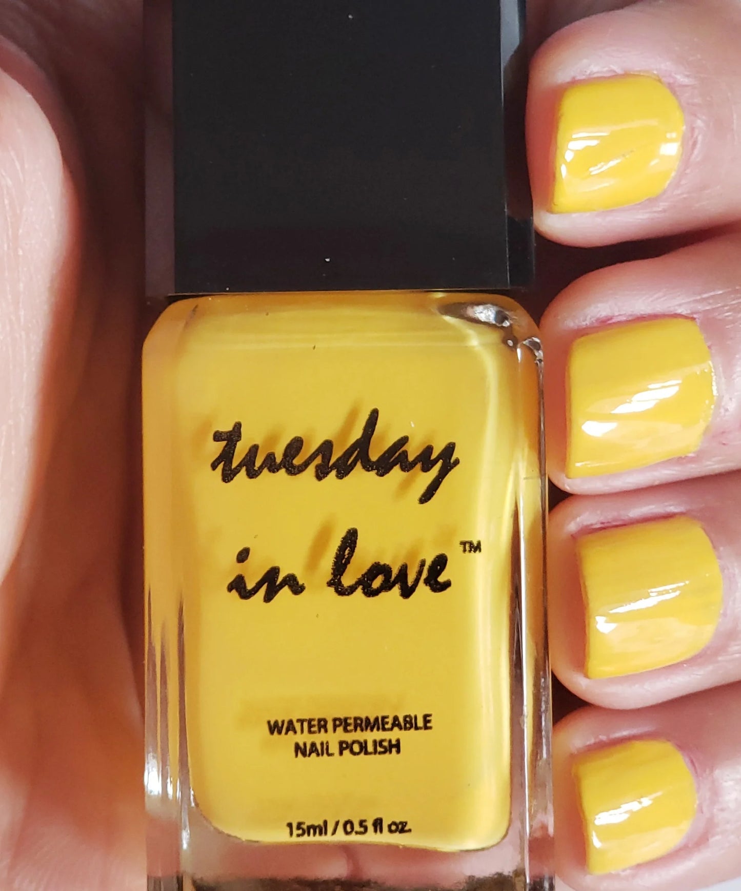 Close-up van vrouwenhand die Sunshine nagellak toont