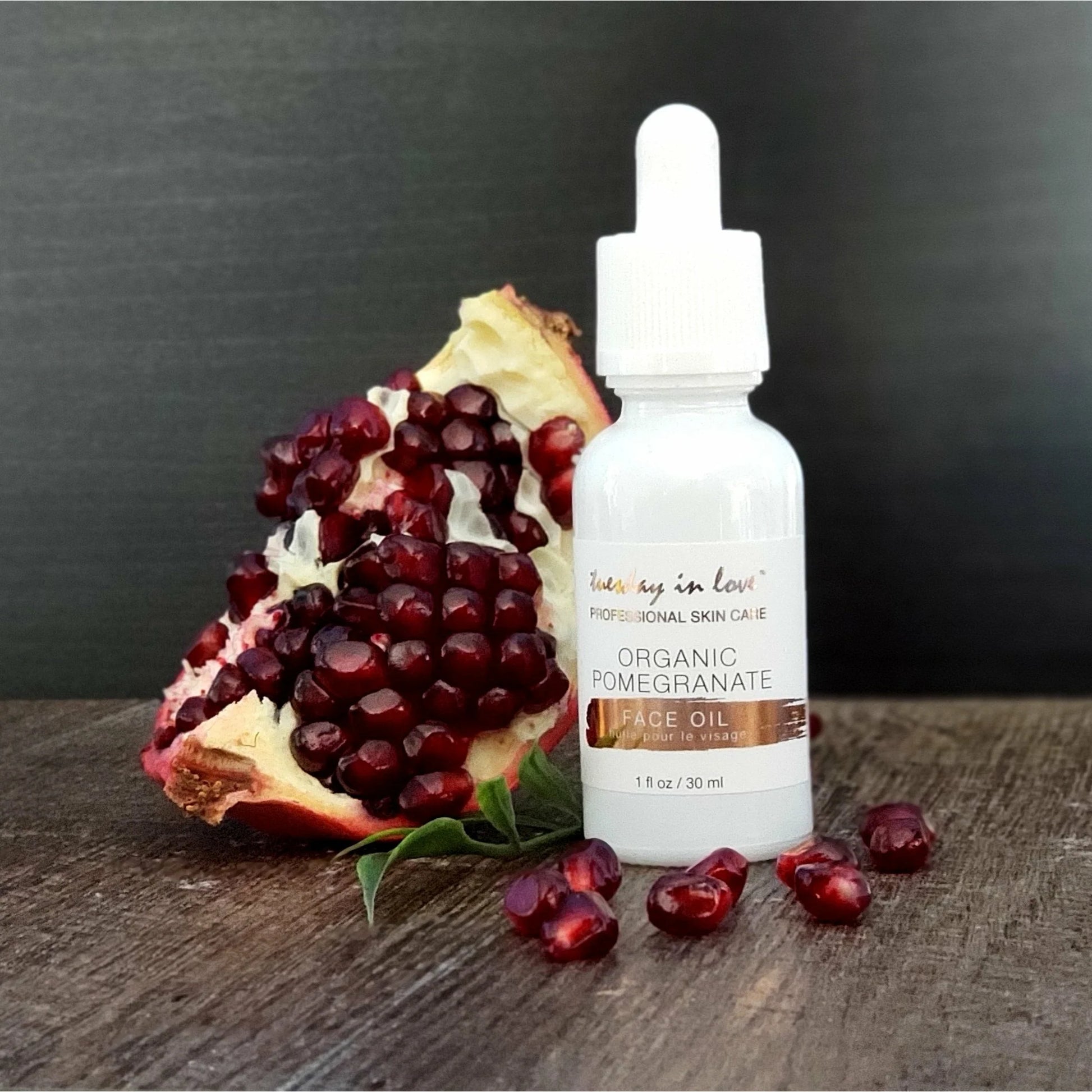 Flacon Organic Pomegranate Face Oil naast granaatappel