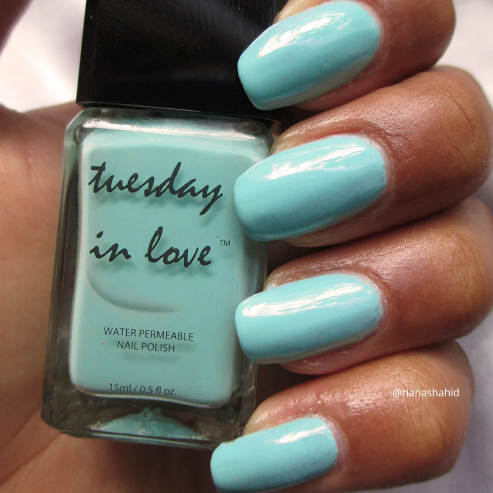 Close-up van de nagels, glanzend in de levendige lichte teal tint.